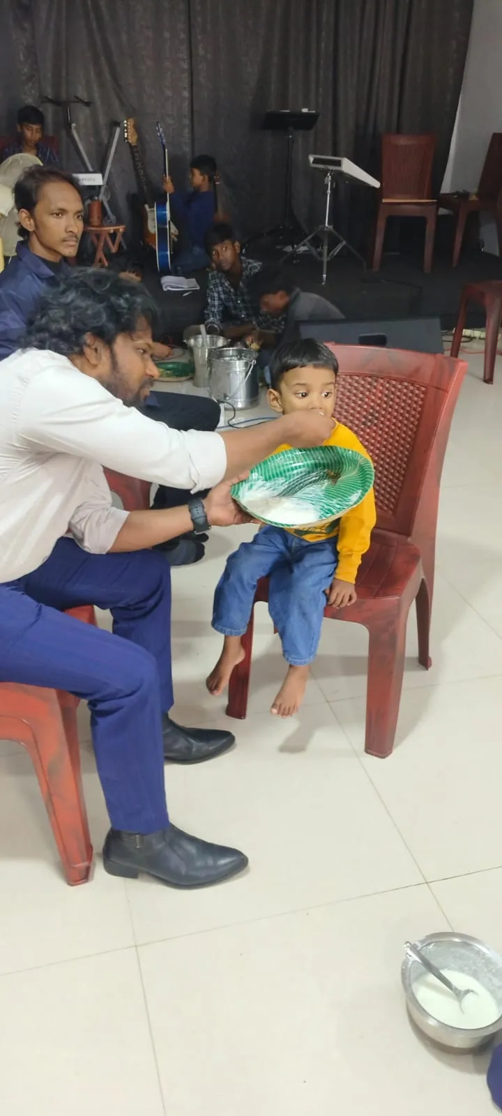One of the boys being fed a meal at the church